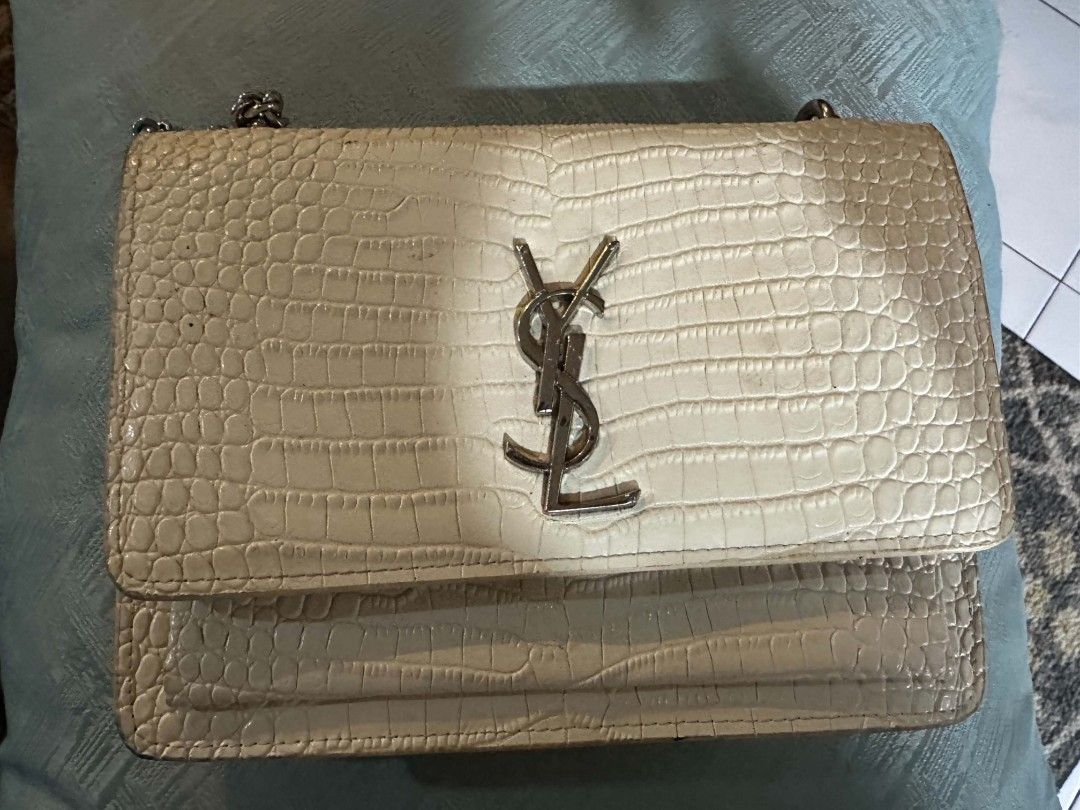 Saint Laurent YSL White Crocodile Embossed Chain Bag (Category: Luxury Bags & Wallets) located in Batangas. Submitted by codexmark (Listing ID 1465649583, Image 1). Description: - Brand: Saint Laurent (YSL) - Material: White crocodile embossed leather - Hardware: Silver-tone with iconic YSL monogram logo - Closure: Secure magnetic snap closure - Interior: Fabric-lined with multiple compartments and a branded slip pocket - Strap: Elegant chain str