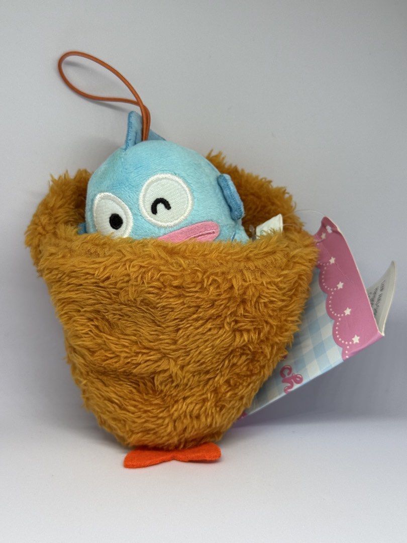 Sanrio Hangyodon Plush Charm and Figure Set (Category: Plushies & Soft Toys) located in Manila. Submitted by silverfalcon_dbc769 (Listing ID 1465749772, Image 2). Description: - Authentic Sanrio Hangyodon merchandise bundle (selling as a set) - Includes plush toy tucked inside a fluffy brown nest pouch with tag attached and an orange strap - Includes a cute turquoise plastic Hangyodon figure with detailed blue fins - Character features: iconic bl