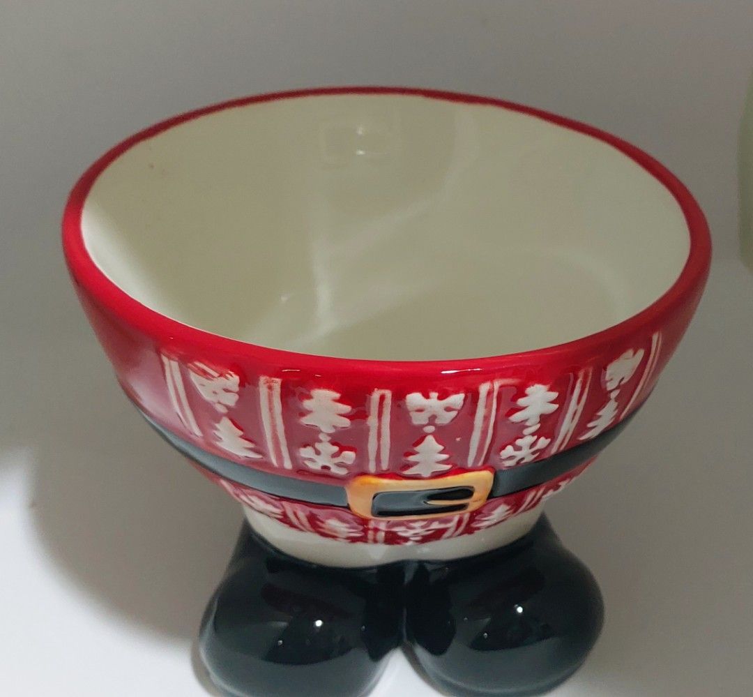 Santa Claus ceramic bowl (Category: Vases & Decorative Bowls) located in Cainta. Submitted by veronica2277 (Listing ID 1465618154, Image 1). Description: - Adorable Santa suit design with red rim, white interior, black belt, and gold buckle - Features cute black boot feet at the bottom for stability and extra charm - Made of durable ceramic, perfect for holiday decor or serving Christmas snacks - Ideal festive gift or addition to your Noche Buena