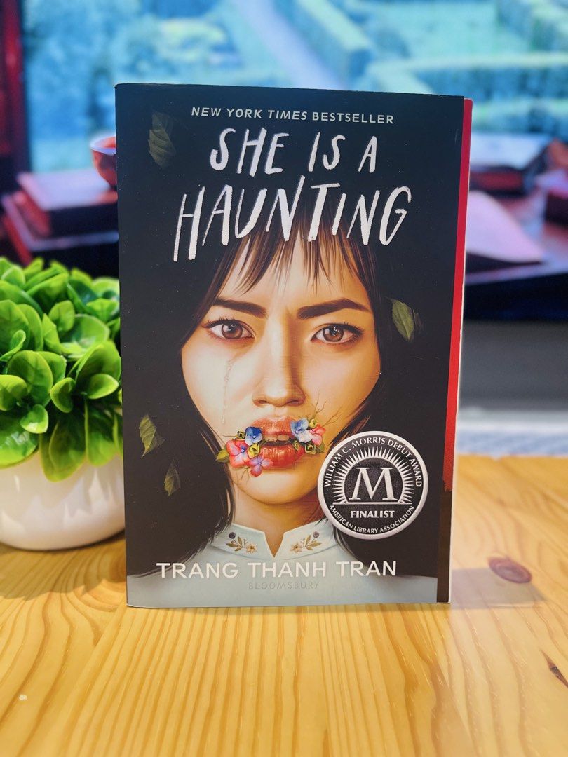 She Is A Haunting by Trang Thanh Tran (Category: Storybooks) located in Makati City. Submitted by pagesandplay (Listing ID 1465747334, Image 1). Description: - Title: She Is A Haunting by Trang Thanh Tran - Format: Paperback (Bloomsbury edition) - Accolades: New York Times bestseller with William C. Morris Debut Award Finalist sticker - Condition: Read once, clean pages, sturdy spine, well-stored on a shelf.