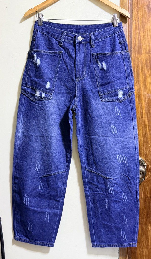 SHEIN Distressed Barrel Jeans Size 26 (Category: Jeans) located in Paete. Submitted by skydruemadison (Listing ID 1465660900, Image 1). Description: - Brand/Model: Shein Distressed Blue Jeans - Size: 26 - Fit: High waist with wide legs - Design: Distressed details on front and back, large front pockets - Material: Cotton, polyester, viscose, and modal blend for a comfortable feel - Care: Wash with like colors - Style: Great for casual, everyday o