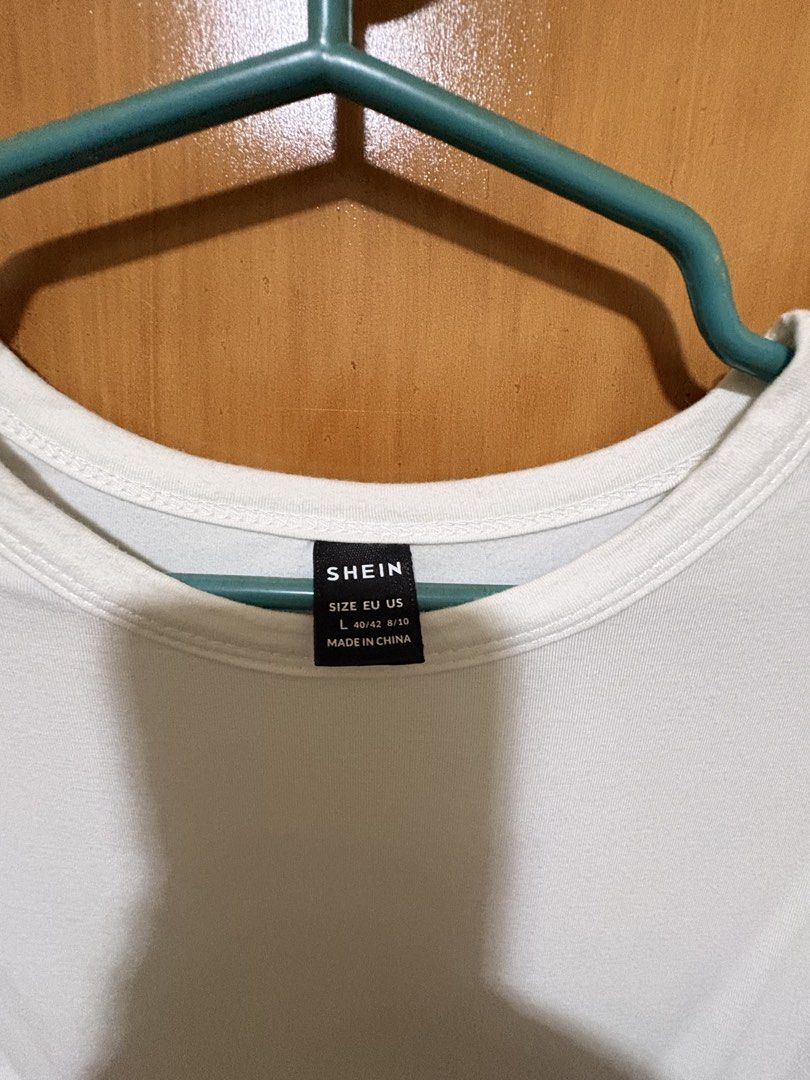 SHEIN White T-Shirt Size L (Category: Shirts) located in Mandaue City. Submitted by klosetfindscebu (Listing ID 1465660928, Image 2). Description: - Brand: SHEIN - Size: L - Color: Solid White - Fit: Relaxed fit with a classic round neckline - Material: Soft and comfortable fabric - Style: Casual everyday wear, easy to pair with jeans or skirts - Condition: Clean and well-maintained wardrobe staple.