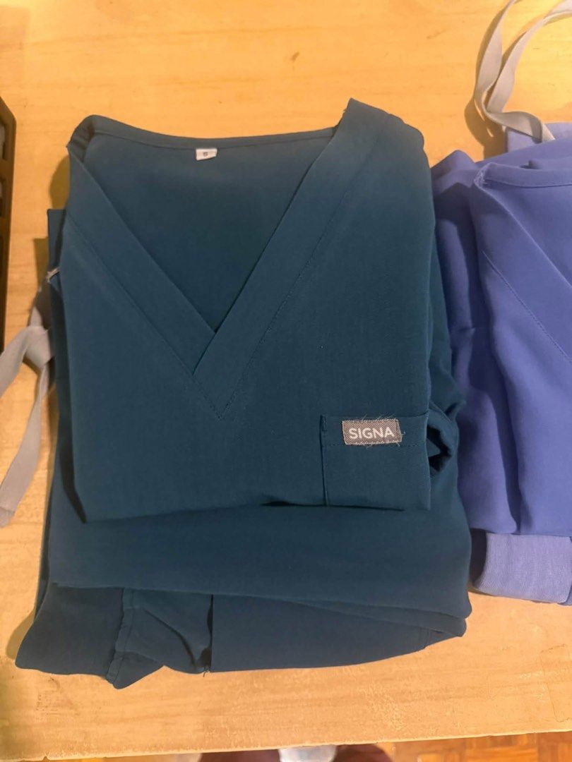 SIGNA Caribbean Scrubsuit (Category: Sets or Coordinates) located in Makati City. Submitted by sohdeclutters_ (Listing ID 1465712458, Image 2). Description: - Brand: SIGNA - Item: Medical scrub set (V-neck top & jogger pants) - Color: Caribbean blue - Size: Small - Details: Top features a front pocket and brand patch; pants have an elastic drawstring waist - Material: Figs like fabric.