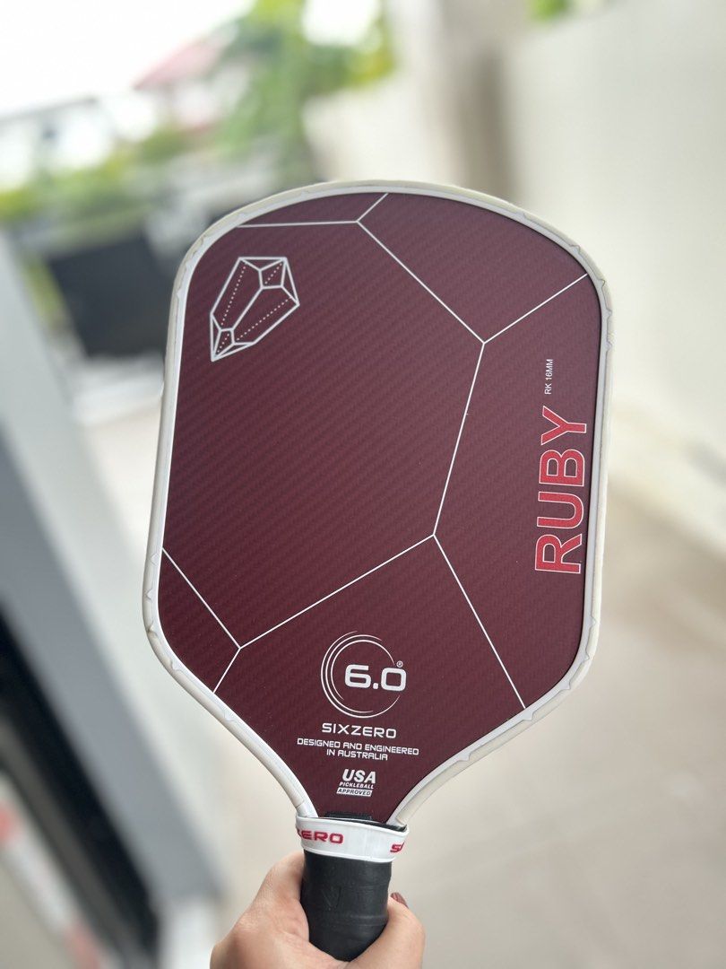Six Zero Ruby 16mm Pickleball Paddle (Category: Racket and Ball Sports) located in Binan City. Submitted by guiltfreefashion (Listing ID 1465587563, Image 1). Description: - Brand/Model: Six Zero Ruby (16mm thickness) - Color/Design: Maroon carbon fiber face with a stylish geometric crystal graphic on the top left - Protection: White edge guard installed around the perimeter - Handle: Black handle featuring a white grip band near the throat - Cer