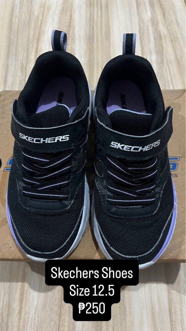 Skechers Shoes Size 12.5 (Category: Babies & Kids Fashion) located in Imus. Submitted by nomsthriftshop (Listing ID 1465616572, Image 1). Description: - Brand: Skechers - Color: Black with purple trim and white midsole - Closure: Velcro straps and elastic laces - Features: Heel pull tab for easy wear - Condition: Worn condition with visible wear on the mesh and strap edges.