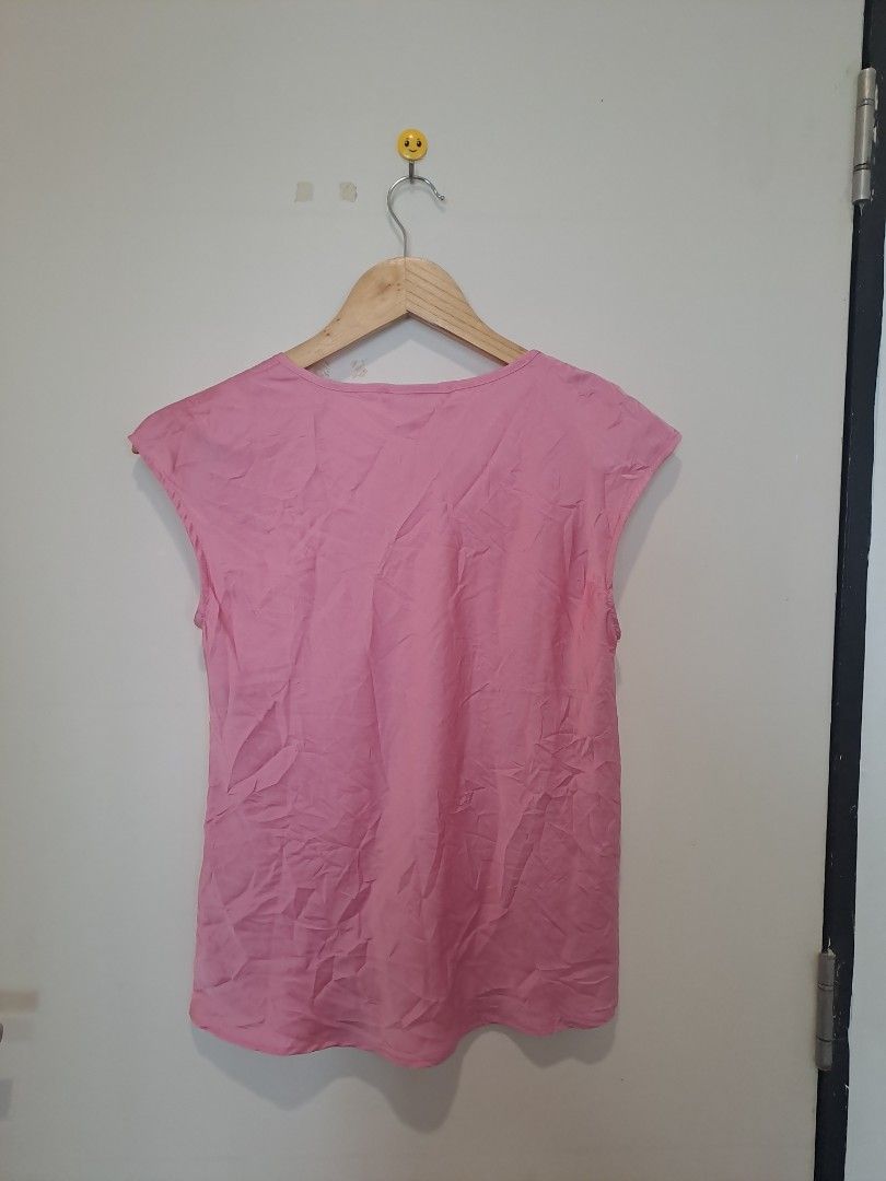 Sleeveless by philosophy (Category: Sleeveless) located in Manila. Submitted by joanbalde39643 (Listing ID 1465670223, Image 3). Description: This is a pink cap-sleeve blouse with a wide scoop neckline. The garment appears to be made from a lightweight, fluid material such as satin, silk, or a viscose blend, given its subtle sheen and drape. The label inside indicates the brand is Philosophy..