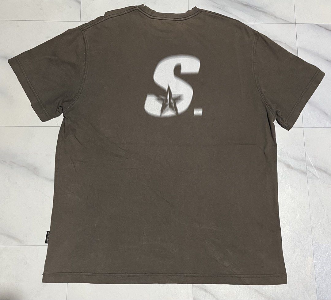 STA. Brown Graphic Tee (Category: Tshirts & Polo Shirts ) located in Cavite. Submitted by christianzuuu (Listing ID 1465725738, Image 2). Description: - Color: Brown with large white 'STA. Last name STA, First name Lucky' front graphic - Design: Large stylized 'S' logo with a star element on the back - Size: 29 inches length x 22.5 inches across the chest (relaxed fit) - Material: Comfortable cotton blend - Condition: Minor fading consistent with