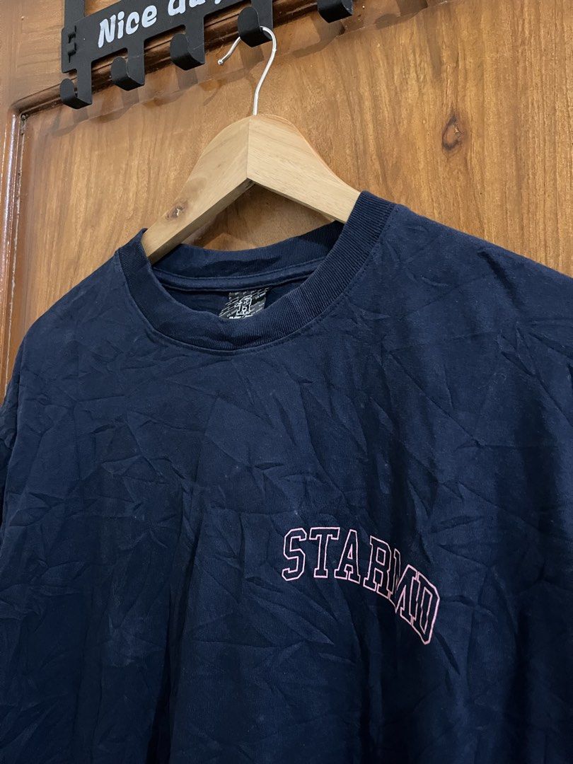 STA_GROUP x Remedy Dark Blue Graphic Tee (Category: Tshirts & Polo Shirts ) located in Bula. Submitted by thrift.wyn (Listing ID 1465599491, Image 3). Description: - Brand: STA_GROUP x Remedy - Color: Dark blue - Design: Small collegiate chest print with a large pink graphic print and star details on the back - Details: Branded woven tag on collar - Fit: Relaxed fit - Material: Comfortable cotton - Condition: Great casual everyday piece.