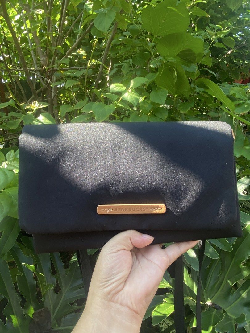 Starbucks Black Messenger Crossbody Bag (Category: Sling Bags) located in Manila. Submitted by cdb_22 (Listing ID 1465597659, Image 1). Description: - Authentic Starbucks black fabric crossbody bag - Features fold-over flap closure with brown leather Siren logo accent - Equipped with comfortable black adjustable straps - Compact yet spacious enough for daily essentials, phone, and wallet - Solid construction and clean exterior - Perfect for every