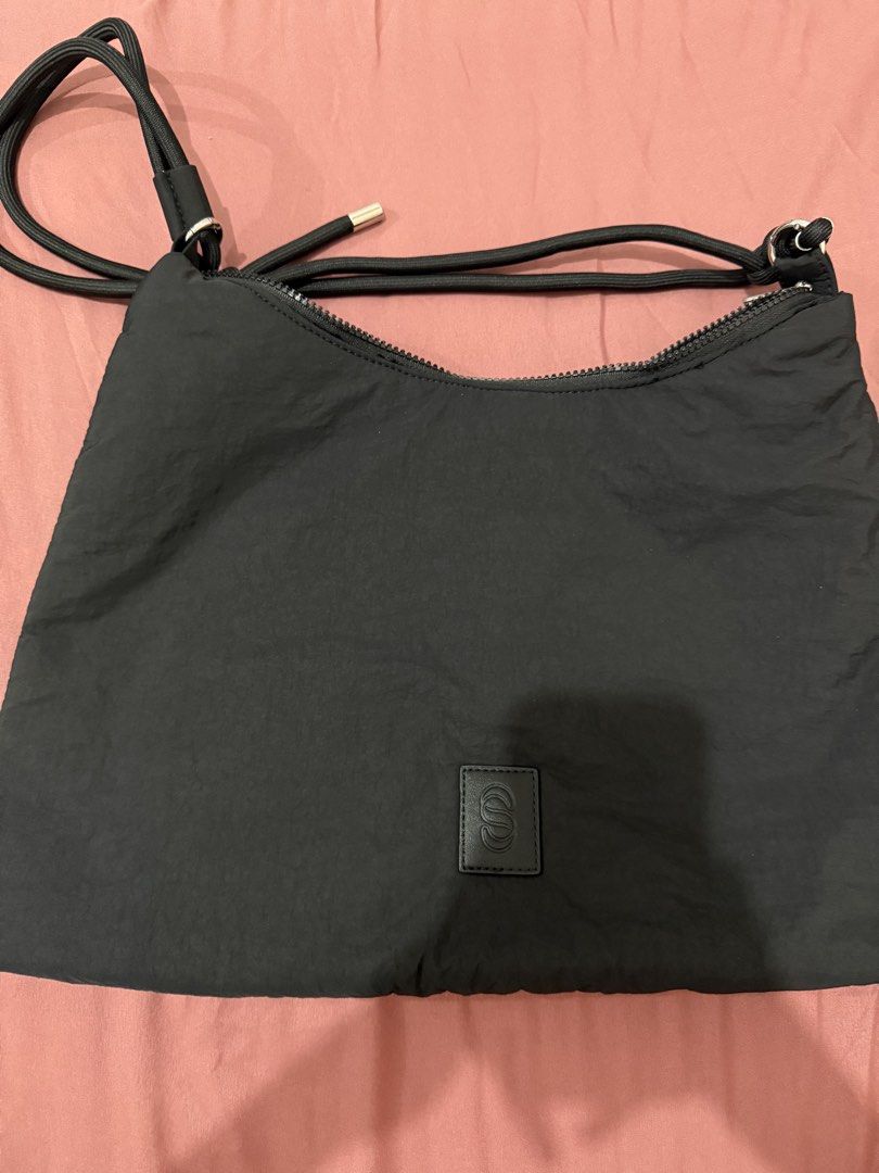 Straighforward Black Nylon Shoulder Bag With Rope Strap (Category: Shoulder Bags) located in Manila. Submitted by aaaine (Listing ID 1465755552, Image 1). Description: - Color & Material: Black nylon, lightweight and easy to carry daily - Straps & Hardware: Thick rope straps with metal aglets and O-ring details - Closure & Interior: Secure top zip closure, dark fabric lining, and one small slip pocket - Branding: Structured leatherette patch with