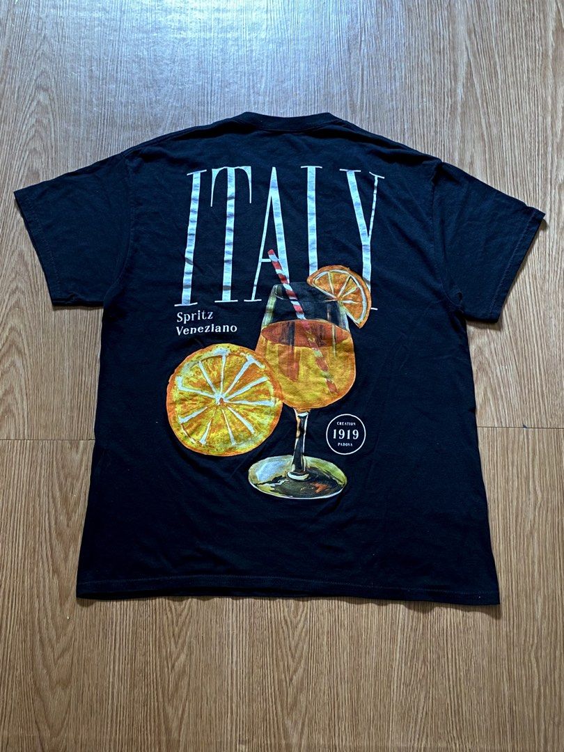 Strange Daze Aperol Spritz Graphic Tee (Category: Shirts) located in Quezon City. Submitted by dcbys (Listing ID 1465617480, Image 1). Description: Classic black crew neck tee with Aperol Spritz chest. Soft, breathable cotton for everyday wear. Clean, simple design that pairs well with jeans or shorts. Features the orange detail for a subtle pop of color. Italy/Spritz graphic on the back..