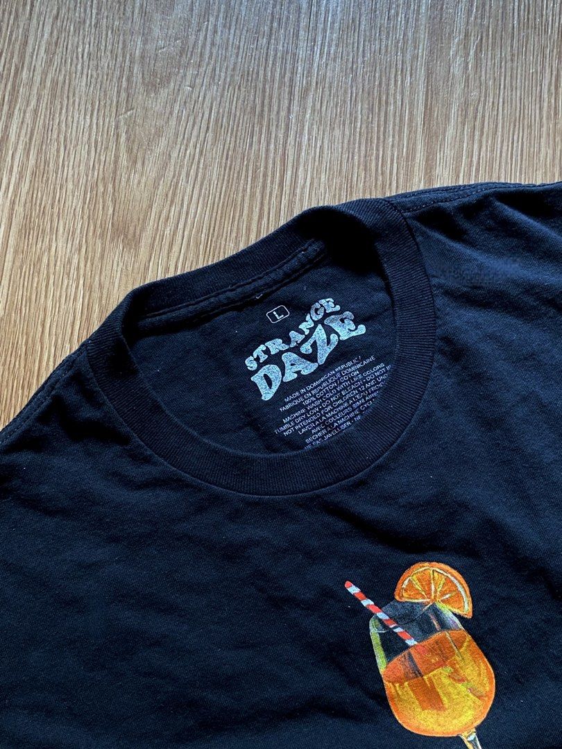 Strange Daze Aperol Spritz Graphic Tee (Category: Shirts) located in Quezon City. Submitted by dcbys (Listing ID 1465617480, Image 3). Description: Classic black crew neck tee with Aperol Spritz chest. Soft, breathable cotton for everyday wear. Clean, simple design that pairs well with jeans or shorts. Features the orange detail for a subtle pop of color. Italy/Spritz graphic on the back..