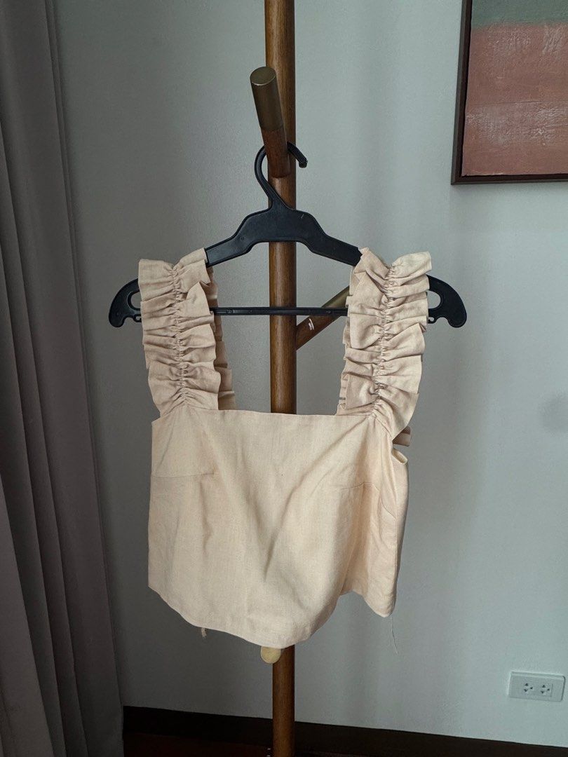 Studio Caca beige ruffled crop top size xs (Category: Sleeveless) located in Pasig City. Submitted by kutleyn (Listing ID 1465653158, Image 1). Description: - Brand: Caca Studio - Size: XS - Color: Beige with cream lining - Design: Thick ruffled straps, square neckline front and back, hidden back zipper - Condition: Excellent, clean fabric with no stains or damage - Style: Super cute piece for casual outings.