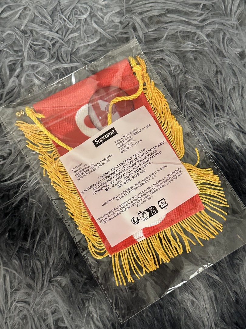 Supreme Mini Pennant Banner Red Gold (Category: Other Merchandise) located in Manila. Submitted by markjason420 (Listing ID 1465647914, Image 2). Description: - Brand: Supreme - Item: Mini pennant flag (Red and white) - Details: Yellow fringe trim, gold hanging string, and suction cup included - Material: 100% polyester, made in China - Condition: Brand new with clear plastic protective sleeve.