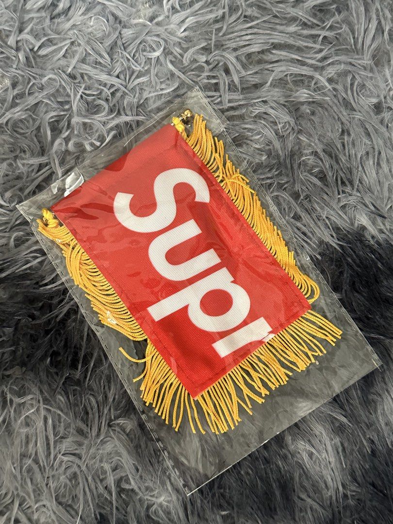 Supreme Mini Pennant Banner Red Gold (Category: Other Merchandise) located in Manila. Submitted by markjason420 (Listing ID 1465647914, Image 1). Description: - Brand: Supreme - Item: Mini pennant flag (Red and white) - Details: Yellow fringe trim, gold hanging string, and suction cup included - Material: 100% polyester, made in China - Condition: Brand new with clear plastic protective sleeve.