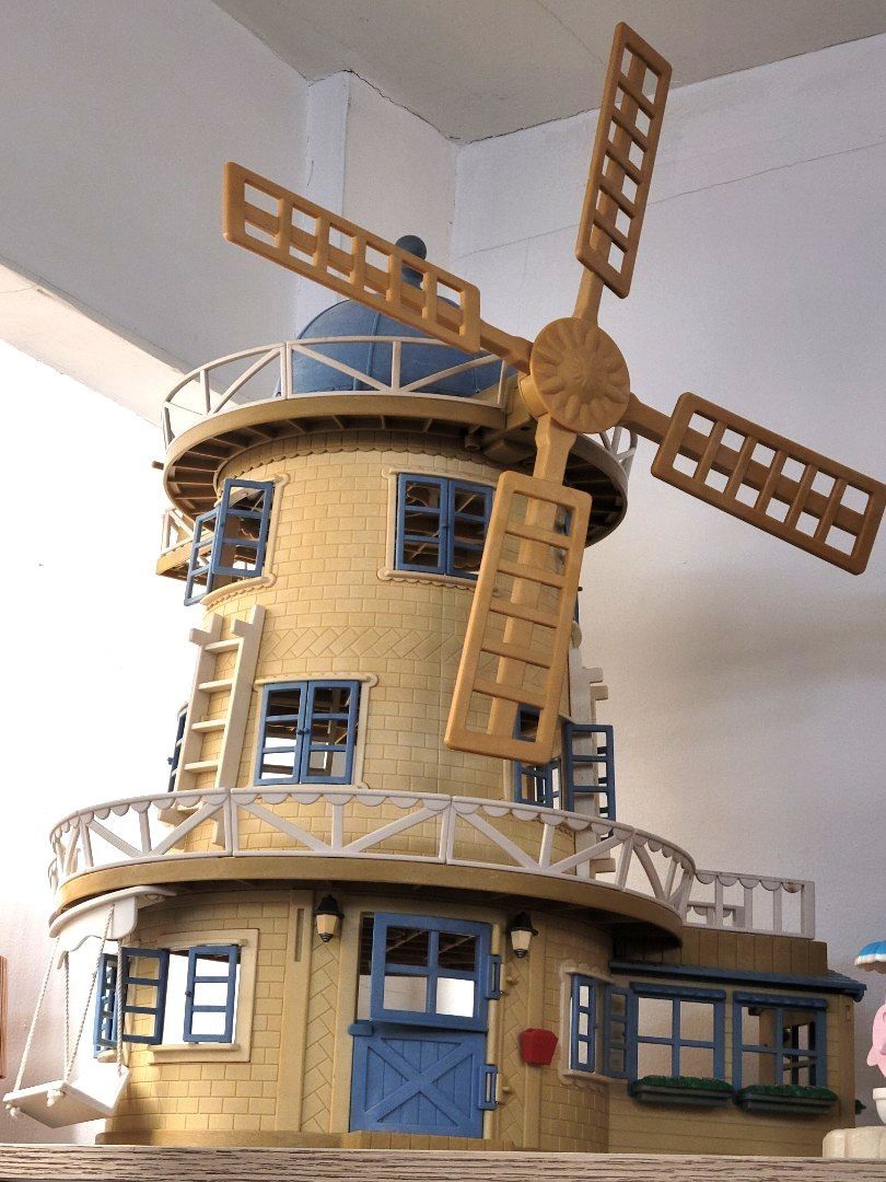 Sylvanian Windmill Toy House (Category: Kids Toys) located in Antipolo. Submitted by dlolin (Listing ID 1465740662, Image 1). Description: Selling my spare 🤗 - Authentic Calico Critters yellow and tan windmill playset - Features working rotating blades, blue window shutters, wooden staircase, and rope swing - Spacious interior with multiple rooms for figures and furniture - Excellent, clean condition with zero major scuffs - Great addition to an