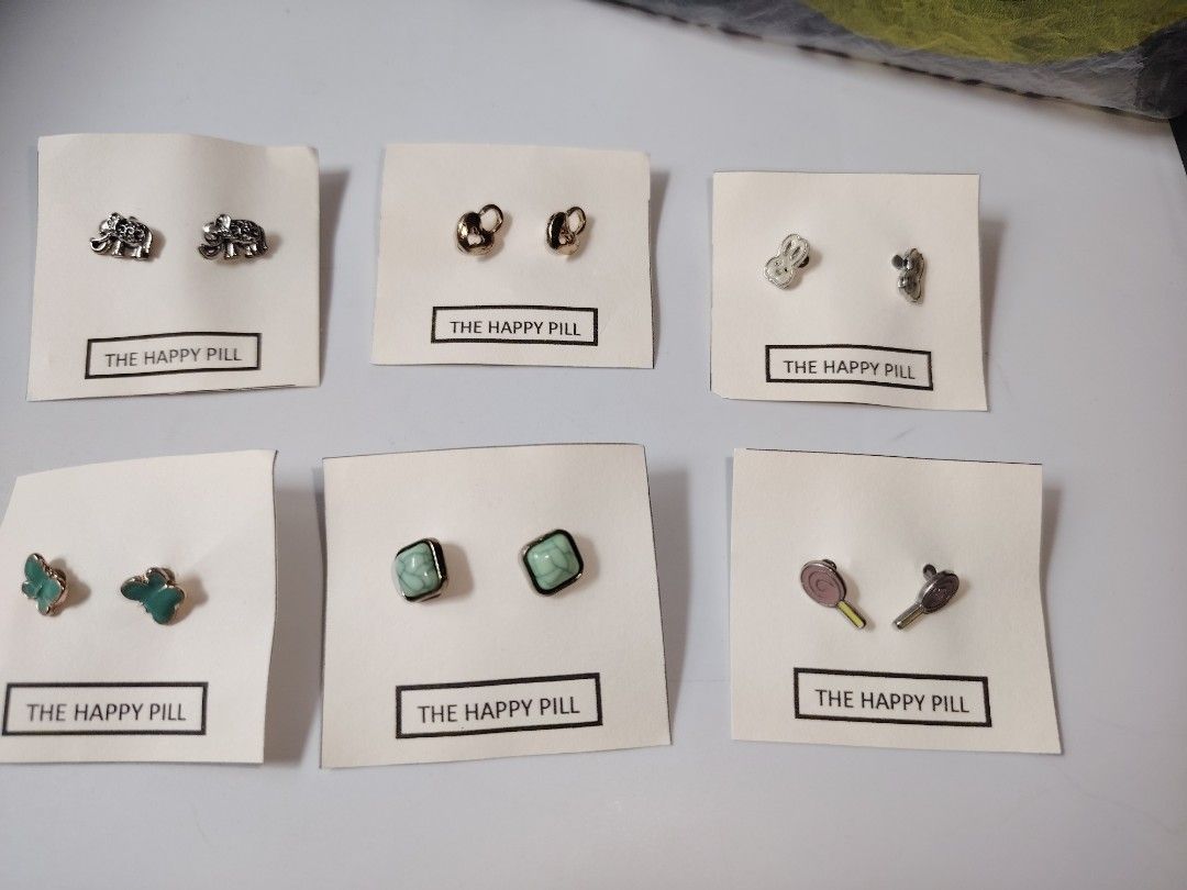 The Happy Pill Stud Earrings Assorted Styles (Category: Earrings) located in Antipolo. Submitted by goodsinger (Listing ID 1465603915, Image 1). Description: - Adorable stud earrings mounted on unique 'Happy Pill' display cards - Variety of cute designs available: elephants, locks, bunnies, butterflies, turquoise stones, and lollipops - Features standard post backs for comfortable daily wear - Fun and playful collection, great for mixing and matc