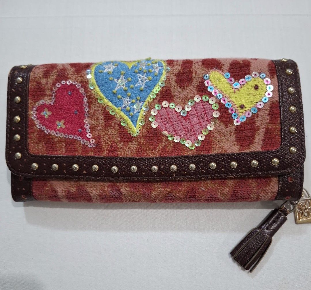 Think Bee! Long Wallet with Hearts and Tassel (Category: Wallets & Card holders) located in Don Carlos. Submitted by PphiXi_Finds (Listing ID 1465725213, Image 1). Description: - Brand: Think Bee! - Material: Brown leather trim and patterned fabric - Exterior: Colorful embroidered heart appliques, sequins, and green/pink hearts on the back - Interior: Pink heart-patterned fabric with multiple card slots and zipped compartments - Extras: Detachabl