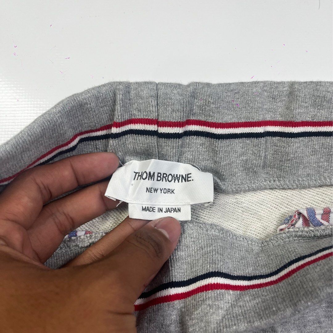 Thom Browne 4-Bar Engineered Sweatpants Grey (Category: Joggers) located in Lucena. Submitted by nifty_finds (Listing ID 1465644809, Image 3). Description: - Brand: Thom Browne - Color: Medium Grey - Size: 1 (Medium) - Material: Premium cotton with soft fleece lining - Features: Signature white 4-bar stripes on left leg, drawstring waist, tricolor grosgrain locker loop, elastic ankle cuffs - Origin: Made in Japan - Condition: Clean fabric through