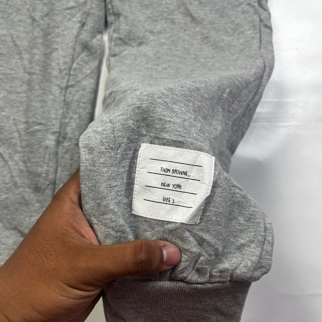 Thom Browne 4-Bar Engineered Sweatpants Grey (Category: Joggers) located in Lucena. Submitted by nifty_finds (Listing ID 1465644809, Image 2). Description: - Brand: Thom Browne - Color: Medium Grey - Size: 1 (Medium) - Material: Premium cotton with soft fleece lining - Features: Signature white 4-bar stripes on left leg, drawstring waist, tricolor grosgrain locker loop, elastic ankle cuffs - Origin: Made in Japan - Condition: Clean fabric through