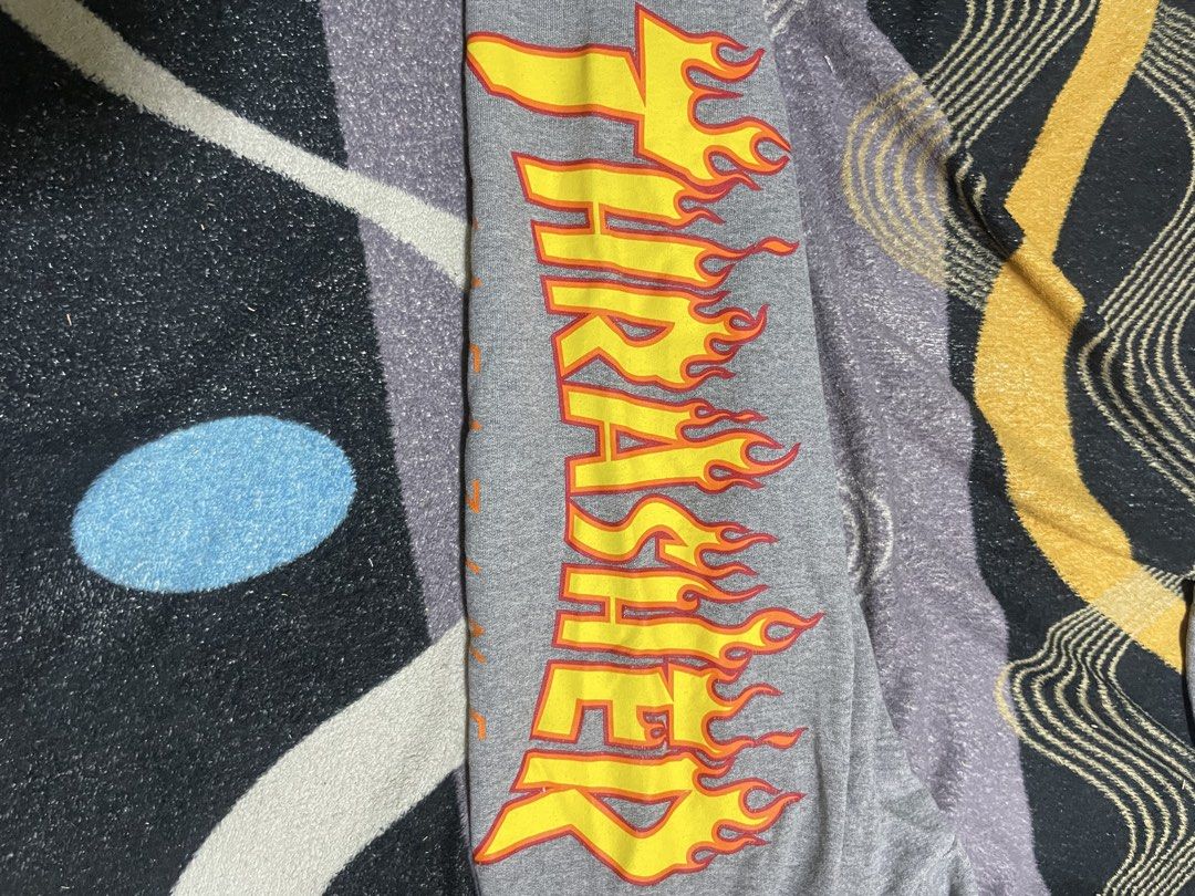 Thrasher Flame Logo Grey Sweatpants (Category: Joggers) located in Mandaue City. Submitted by anthony457 (Listing ID 1465645301, Image 2). Description: - Brand: Thrasher - Item: Flame graphic sweatpants - Color: Grey with yellow and red flames on the left leg - Features: Warm fleece lining, elastic waistband, and ribbed ankle cuffs - Condition: Good classic skate piece with a minor flaw near the right hem (please check photos closely).