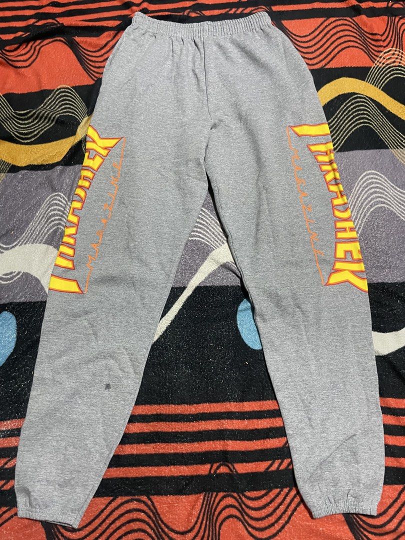 Thrasher Flame Logo Grey Sweatpants (Category: Joggers) located in Mandaue City. Submitted by anthony457 (Listing ID 1465645301, Image 1). Description: - Brand: Thrasher - Item: Flame graphic sweatpants - Color: Grey with yellow and red flames on the left leg - Features: Warm fleece lining, elastic waistband, and ribbed ankle cuffs - Condition: Good classic skate piece with a minor flaw near the right hem (please check photos closely).