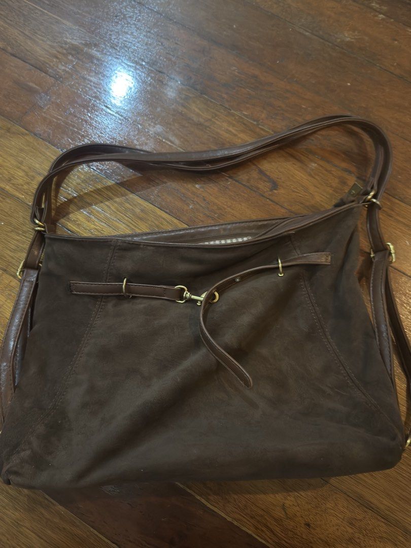 Three way Brown suede shoulder bag with strap detail (Category: Shoulder Bags) located in Taguig. Submitted by princesssantoss (Listing ID 1465586747, Image 1). Description: - Material: Brown faux suede with brass-toned hardware - Closure: Secure zip-top closure - Interior: Cute striped fabric lining with a handy zippered pocket - Capacity: Roomy enough for your daily essentials - Straps: Dual shoulder straps for comfortable carrying.