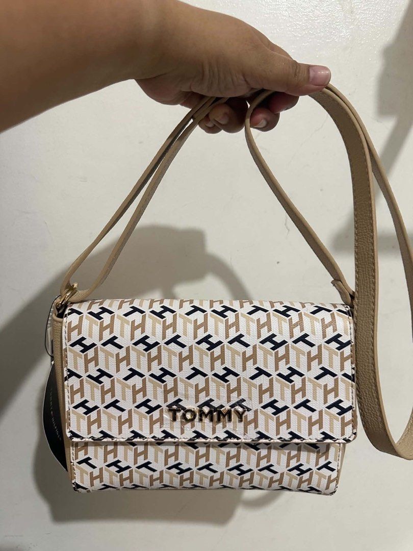 Tommy Hilfiger Monogram Crossbody Bag (Category: Cross-body Bags) located in Dagupan City. Submitted by vallureph (Listing ID 1465588658, Image 2). Description: - Brand: Tommy Hilfiger - Condition: Brand new with tag attached - Design: Beige, white, and navy geometric monogram print with gold-tone hardware - Structure: Compact, structured silhouette with front flap closure - Strap: Adjustable neutral tan faux leather shoulder strap - Usage: Ideal