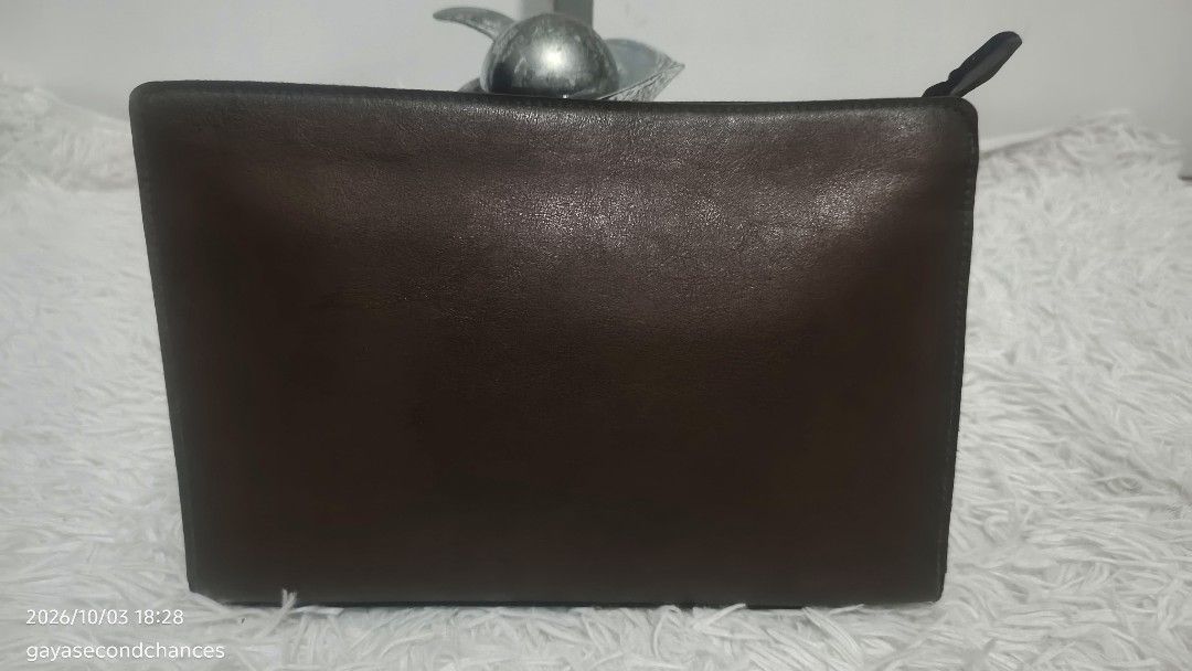 TOP GALLANT BROWN LEATHER CLUTCH BAG (Category: Belt bags, Clutches and Pouches) located in Kalibo. Submitted by secondchances.thriftsh8p (Listing ID 1465677557, Image 2). Description: - Brand: Top Gallant - Material: Brown leather - Closure: Secure zip-around design - Pocket: Handy front zippered pocket - Structure: Holds its shape with reinforced black side gussets - Details: Metal brand plaque and solid hardware.