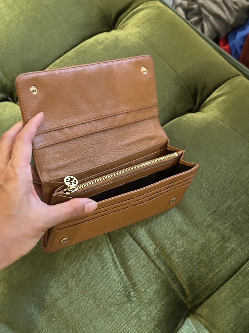 Tory Burch Tan Leather Long Wallet (Category: Wallets & Card holders) located in Pasig City. Submitted by erikiii (Listing ID 1465661368, Image 3). Description: - Authentic Tory Burch long wallet in versatile tan pebbled leather - Elegant gold-tone hardware featuring the iconic double T logo plaque - Secure snap button closure - Interior includes multiple card slots, spacious bill compartments, and a zippered coin pocket - Condition: Shows normal
