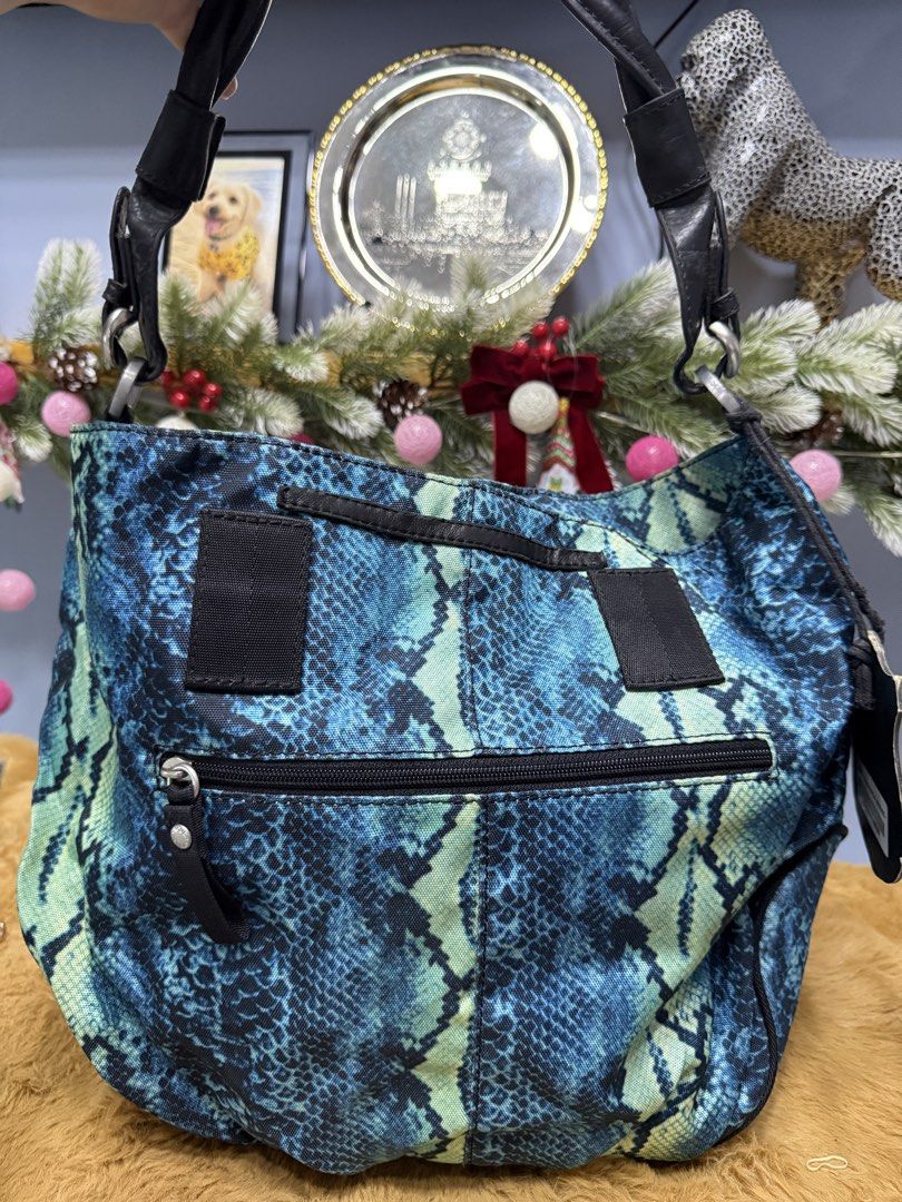 Tough Jeansmith Blue Snake Print Shoulder Bag (Category: Shoulder Bags) located in Alaminos. Submitted by jhean1323 (Listing ID 1465584878, Image 2). Description: - Brand: Tough Jeansmith - Design: Blue and green snake print with black leather trim - Details: Silver studs and stylish hanging tassels on front zippers - Closure: Secure magnetic button on the front - Interior: Vibrant purple fabric lining with built-in zipper compartments and slip p