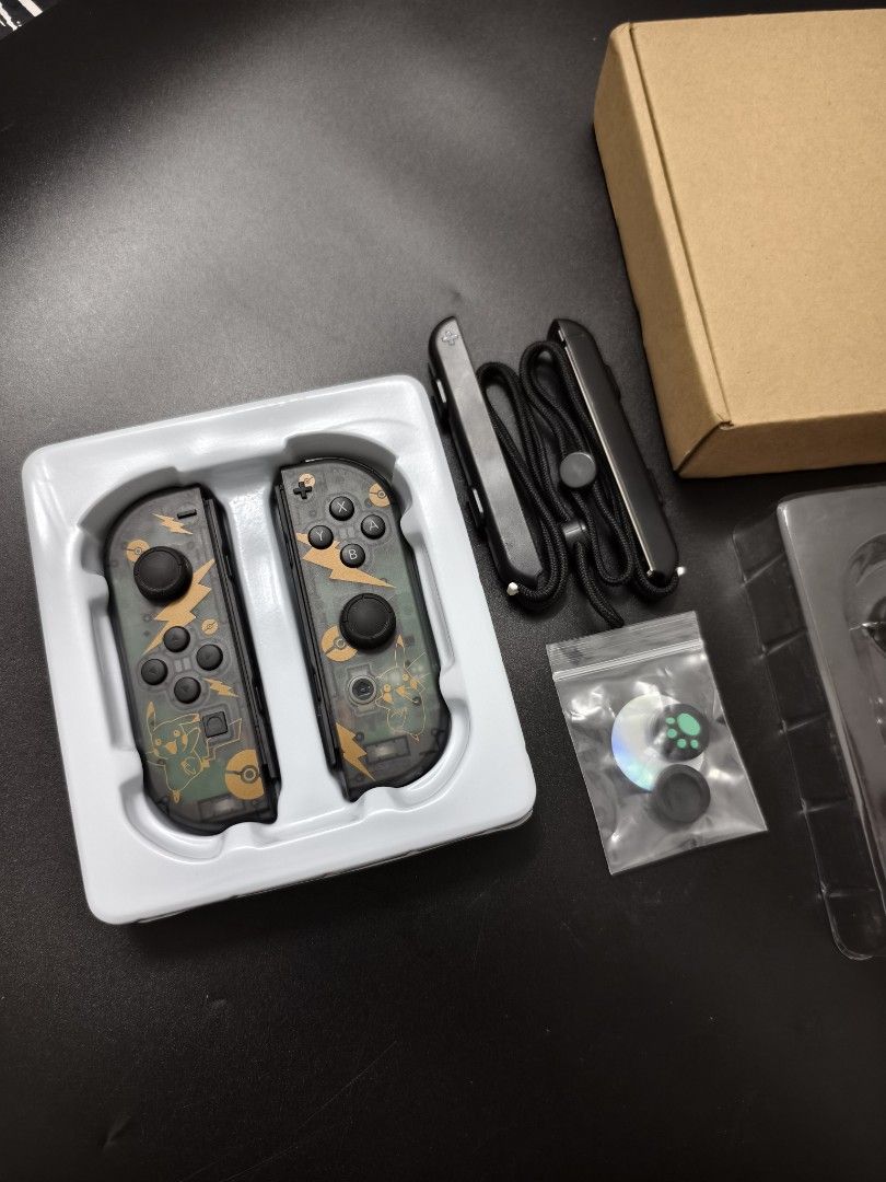 Transparent Black Pikachu Nintendo Switch Joy-Con Shell Replacement (Category: Controllers) located in Angeles City. Submitted by measaliman02351 (Listing ID 1465736086, Image 3). Description: - Condition: Brand new, unused in original box and plastic tray - Design: Transparent black with custom Pikachu and lightning bolt graphics - Compatibility: Replacement housings for Nintendo Switch Joy-Cons - Includes: Matching wrist straps and thumb grip c