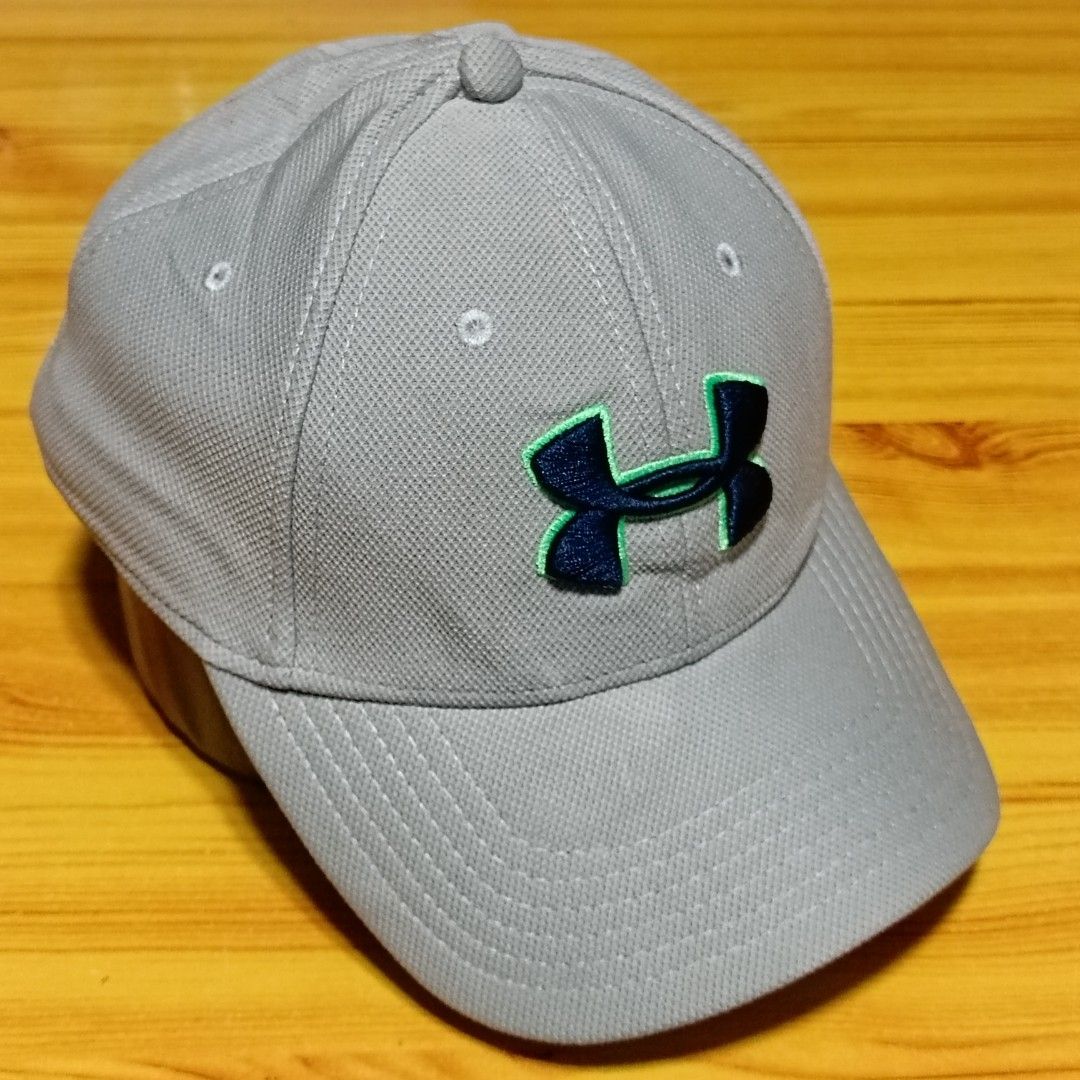 Under Armour Grey Cap with Green and Navy Logo (Category: Caps & Hats) located in Manila. Submitted by caps08 (Listing ID 1465745436, Image 1). Description: - Brand: Under Armour - Color: Grey with navy blue and neon green accents - Material: 100% lightweight polyester - Size: MD/LG - Condition: Clean and well-maintained - Features: Embroidered front logo, back branding, and top ventilation eyelets.