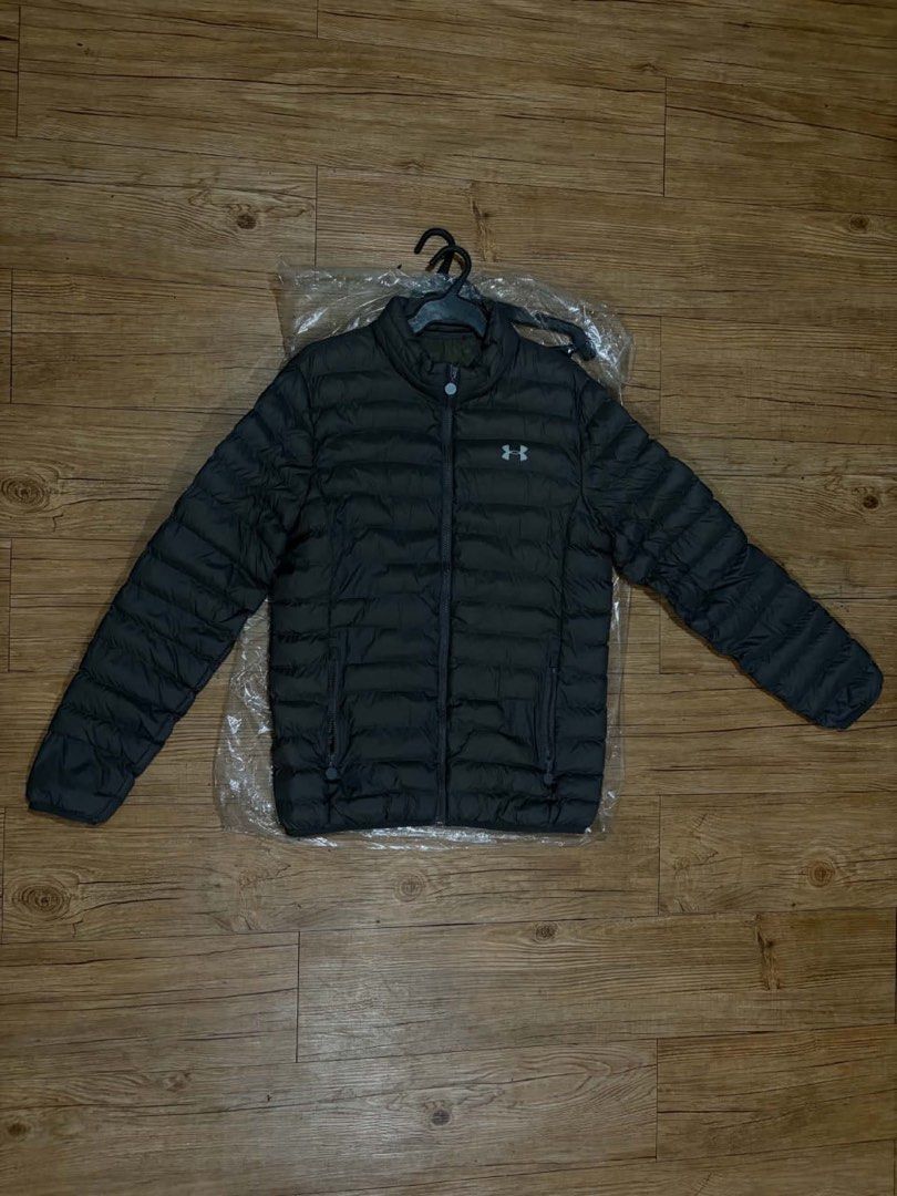 Under Armour Puffer Jacket Dark Grey (Category: Coats, Jackets and Outerwear) located in Mandaluyong City. Submitted by zaiampiloquio (Listing ID 1465608453, Image 1). Description: - Brand: Under Armour - Color: Dark grey with small white logo - Style: Quilted puffer jacket with full zip and high collar - Pockets: Convenient side zip pockets - Measurements: ~22" chest across, ~27" length top to bottom - Condition: Clean and ready to wear.
