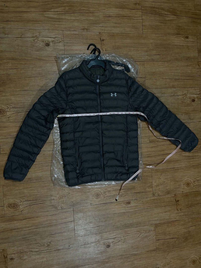 Under Armour Puffer Jacket Dark Grey (Category: Coats, Jackets and Outerwear) located in Mandaluyong City. Submitted by zaiampiloquio (Listing ID 1465608453, Image 2). Description: - Brand: Under Armour - Color: Dark grey with small white logo - Style: Quilted puffer jacket with full zip and high collar - Pockets: Convenient side zip pockets - Measurements: ~22" chest across, ~27" length top to bottom - Condition: Clean and ready to wear.
