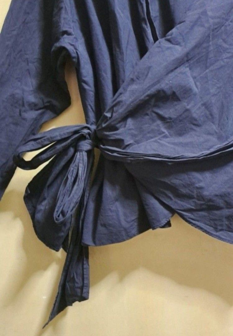 Uniqlo Navy Blue Wrap Blouse (Category: Blouses) located in Manila. Submitted by thrifter_lifestyle (Listing ID 1465691347, Image 3). Description: Brand: Uniqlo Material: Cotton Long Sleeves It's a full wrap around the waist blouse, which can be ribboned on right side (see photo) No issues 😀 Actually looks nicer when ironed or steamed, photos shows it fresh from laundry✌🏻 RFS: shifted to WFH, no need for corporate clothes.
