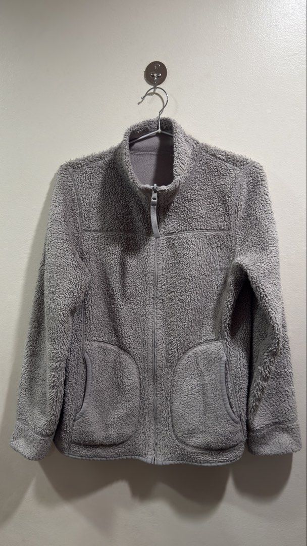 Uniqlo Reversible Fleece Jacket (Category: Coats, Jackets and Outerwear) located in Cebu City. Submitted by ngl.prelovedstuff (Listing ID 1465602136, Image 2). Description: This item is a Uniqlo Reversible Fleece Jacket in grey. It features a plush, high-pile teddy or boa fleece on one side with characteristic curved front patch pockets, a high stand collar, and a full-zip front closure. The interior consists of a smoother, standard microfleece l