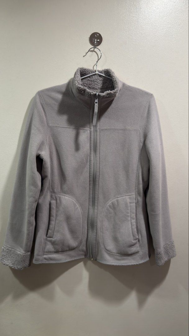 Uniqlo Reversible Fleece Jacket (Category: Coats, Jackets and Outerwear) located in Cebu City. Submitted by ngl.prelovedstuff (Listing ID 1465602136, Image 1). Description: This item is a Uniqlo Reversible Fleece Jacket in grey. It features a plush, high-pile teddy or boa fleece on one side with characteristic curved front patch pockets, a high stand collar, and a full-zip front closure. The interior consists of a smoother, standard microfleece l