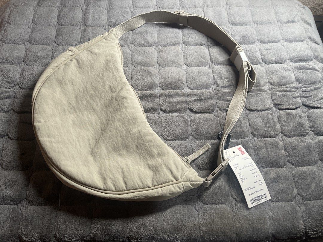 Uniqlo Round Mini Shoulder Bag Beige (Category: Shoulder Bags) located in Quezon City. Submitted by donnabelle7572 (Listing ID 1465614943, Image 1). Description: - Brand: Uniqlo - Style: Round Mini Shoulder Bag (Half-moon shape) - Color: Beige - Condition: Brand new with tags (BNWT) - Material: Lightweight, water-resistant nylon fabric with top zip closure - Features: Long adjustable strap, highly packable and easy to fold - Dimensions: W28cm x H