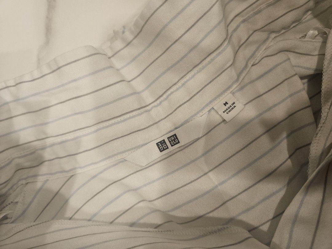 Uniqlo three-quarter length Blouse Size M (Category: Blouses) located in Muntinlupa City. Submitted by aremvy (Listing ID 1465632814, Image 2). Description: Preloved Uniqlo Blouse - Size: M - Design: White with grey and blue vertical stripes, high collar with V-slit front - Sleeves: Three-quarter length - Style: Versatile piece, great for casual work outfits or weekend wear .
