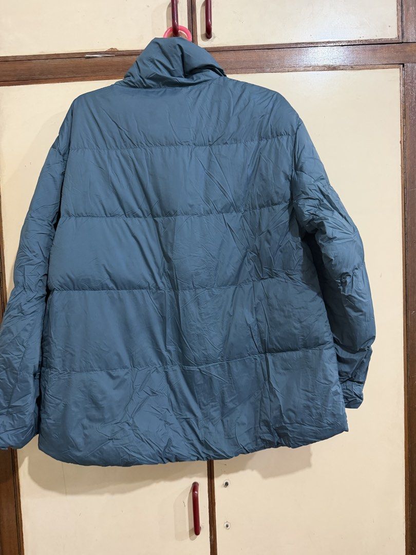 Uniqlo Ultra Light Down Jacket Blue M (Category: Coats, Jackets and Outerwear) located in Manila. Submitted by preloved_new_forsale (Listing ID 1465638270, Image 2). Description: - Brand: Uniqlo Ultra Light Down jacket - Color: Muted blue - Size: Medium (M) - Design: Quilted puffer style with horizontal baffling and high collar - Closure: Convenient snap button front - Extras: Includes original matching storage pouch with printed branding - Featu