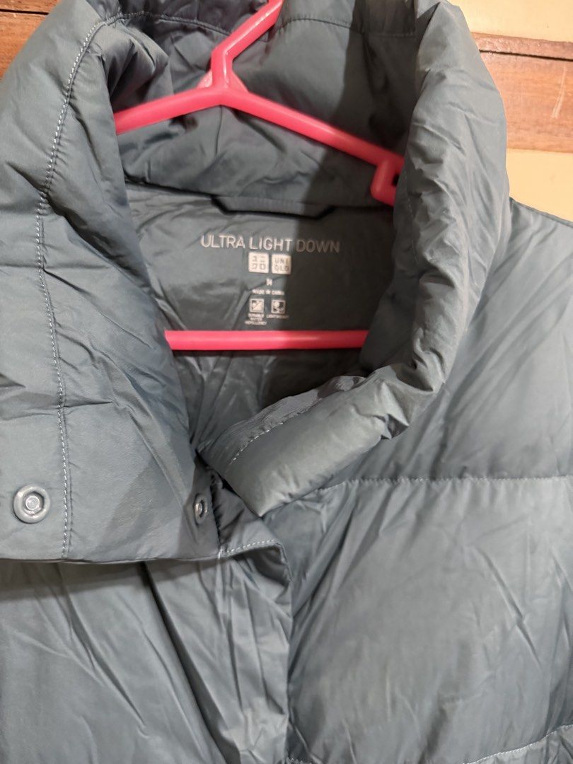 Uniqlo Ultra Light Down Jacket Blue M (Category: Coats, Jackets and Outerwear) located in Manila. Submitted by preloved_new_forsale (Listing ID 1465638270, Image 3). Description: - Brand: Uniqlo Ultra Light Down jacket - Color: Muted blue - Size: Medium (M) - Design: Quilted puffer style with horizontal baffling and high collar - Closure: Convenient snap button front - Extras: Includes original matching storage pouch with printed branding - Featu