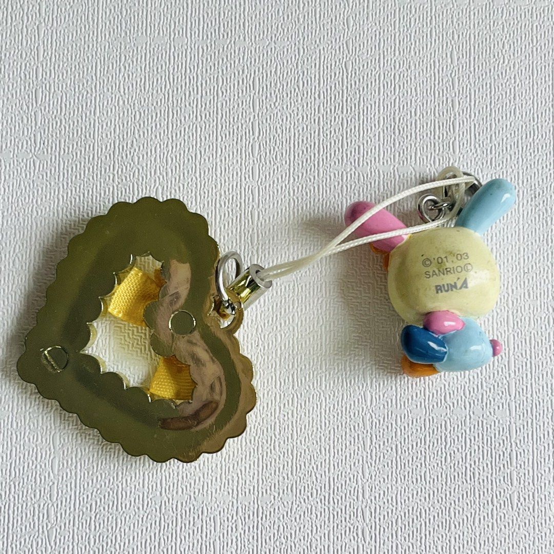 Usahana Sanrio 2001 2003 Phone Charm (Category: Charms) located in Cabuyao City. Submitted by nyannyancore (Listing ID 1465712845, Image 2). Description: - Authentic vintage Sanrio x Runa phone strap (©'01, '03) - Features an adorable bunny with mismatched ears and flower detail - Accented with a gold rhinestone heart charm and yellow polka dot ribbon - Includes white strap loop - Perfect rare collectible for Sanrio lovers and Y2K aesthetic fans.
