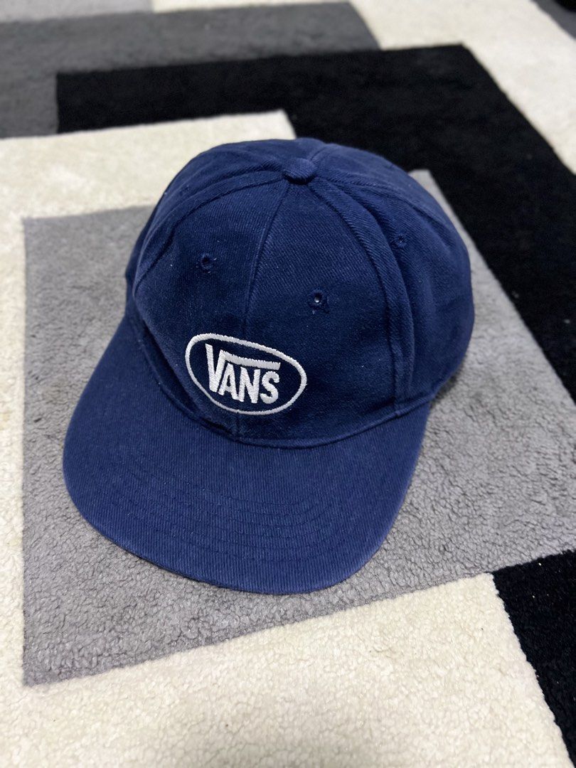 Vans Blue Oval Logo Snapback Cap (Category: Caps & Hats) located in Calasiao. Submitted by pb.supply_v2 (Listing ID 1465752532, Image 1). Description: - Brand: Vans - Color: Classic Navy Blue with white embroidered oval logo - Design: Six-panel unstructured build with metal eyelets for breathability - Fit: Adjustable snapback closure for a custom fit - Style: Versatile everyday casual streetwear.