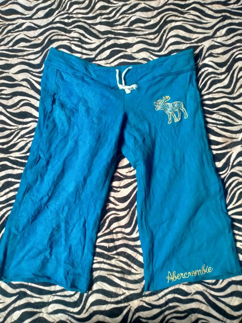 vintage turquoise Abercrombie Capri (Category: Other Bottoms) located in Maco. Submitted by nothingabove300shop (Listing ID 1465614491, Image 1). Description: AI Overview The image shows a pair of vintage turquoise/blue Y2K Abercrombie & Fitch sweatpant capris or shorts featuring a signature moose logo with glitter details and an "Abercrombie" script logo near the hem. size-L ( adjustable).