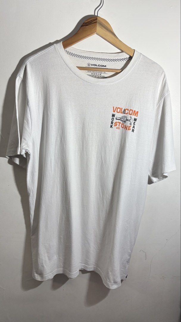 Volcom Work Wear Stone Co T-Shirt White M (Category: Tshirts & Polo Shirts ) located in Manila. Submitted by adaalea_14 (Listing ID 1465742983, Image 1). Description: - Brand/Model: Volcom Work Wear Stone Co Graphic T-Shirt - Color: White - Size: Medium (M) - Material: 100% Cotton (Made in India) - Design: Small hammer & fist chest print, large matching back graphic - Condition: Good overall, with a small hole near the bottom back graphic - Care: