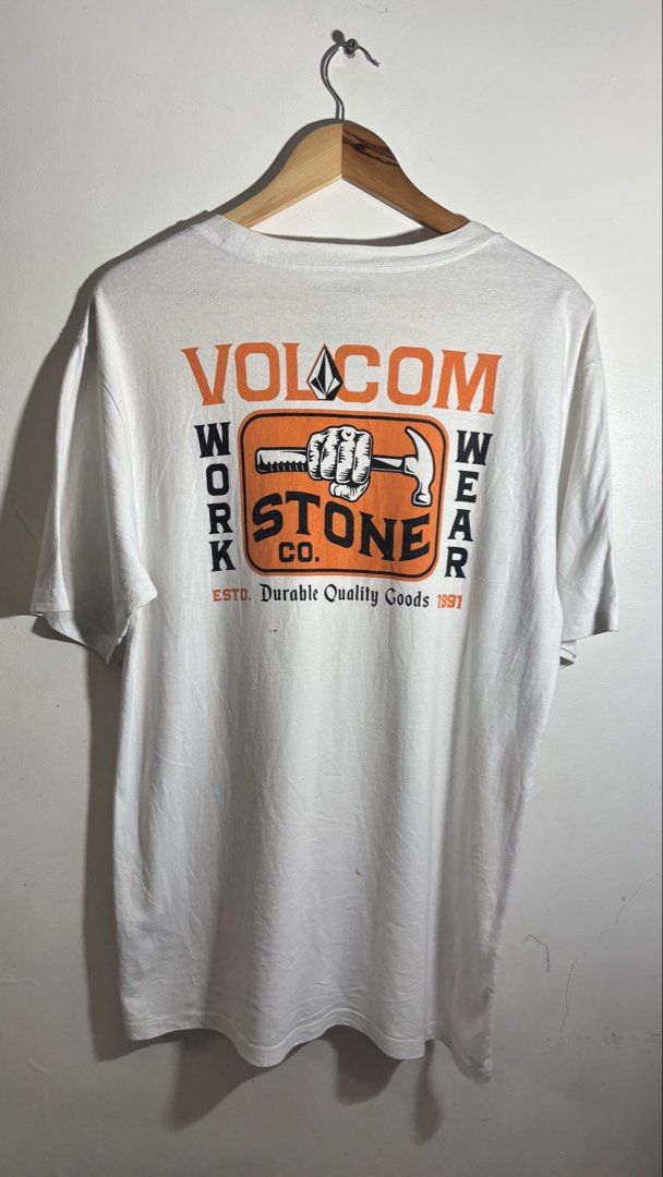 Volcom Work Wear Stone Co T-Shirt White M (Category: Tshirts & Polo Shirts ) located in Manila. Submitted by adaalea_14 (Listing ID 1465742983, Image 2). Description: - Brand/Model: Volcom Work Wear Stone Co Graphic T-Shirt - Color: White - Size: Medium (M) - Material: 100% Cotton (Made in India) - Design: Small hammer & fist chest print, large matching back graphic - Condition: Good overall, with a small hole near the bottom back graphic - Care: