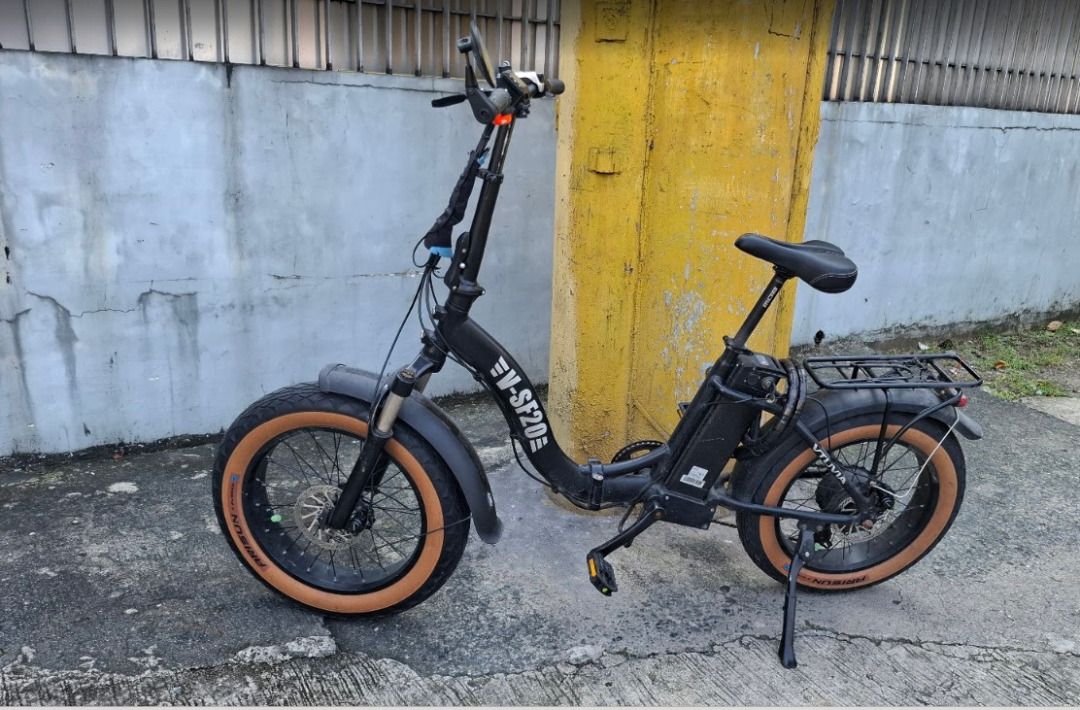 VTUVIA SF20 Foldable Step-Thru Electric Bike (Category: Bicycles) located in Manila. Submitted by sellingmystuffhere (Listing ID 1465637932, Image 1). Description: - Model: EV-SF20 Folding Electric Bike - This is not the updated SF20H variant - Color: Black with 20" x 4.0" fat tires (with stylish tan sidewalls) - Features: Front suspension fork, rear cargo rack, mudguards, and handlebar display computer - Front suspension is stuck, due to manual 