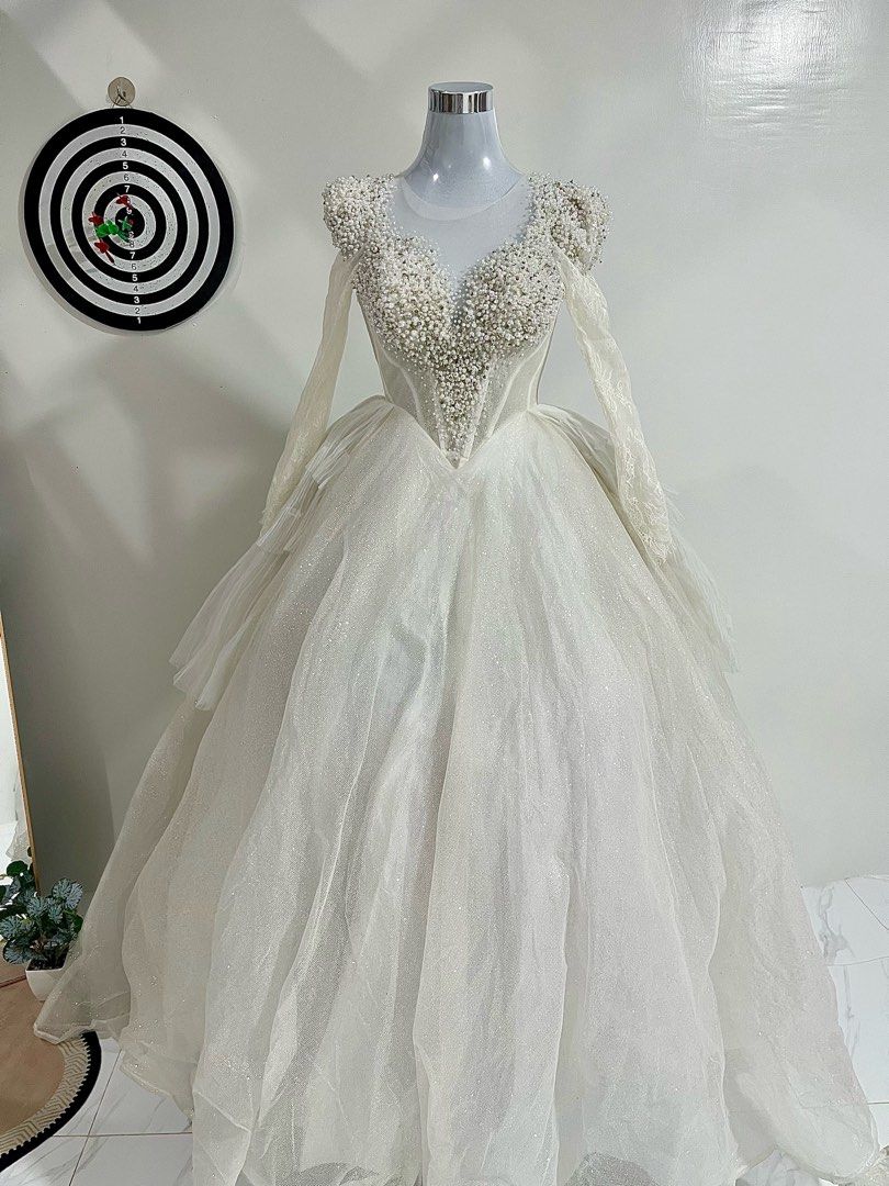 Wedding Gown (Category: Evening dresses & gowns) located in Manila. Submitted by macloset11 (Listing ID 1465655420, Image 2). Description: - Color: Stunning white - Style: Voluminous ball gown with a structured corset torso - Bodice: Plunging sweetheart neckline with heavy pearl and bead detailing - Sleeves: Sheer long lace sleeves and cap sleeves - Skirt: Multi-layered tulle with subtle all-over glitter - Length: Floor-length with a full silhoue