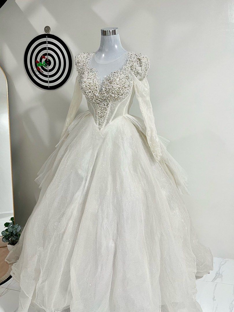 Wedding Gown (Category: Evening dresses & gowns) located in Manila. Submitted by macloset11 (Listing ID 1465655420, Image 1). Description: - Color: Stunning white - Style: Voluminous ball gown with a structured corset torso - Bodice: Plunging sweetheart neckline with heavy pearl and bead detailing - Sleeves: Sheer long lace sleeves and cap sleeves - Skirt: Multi-layered tulle with subtle all-over glitter - Length: Floor-length with a full silhoue
